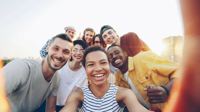 Grupo de jovens reunidos para uma selfie ao pôr do sol